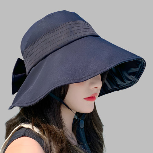 Navy blue sun hat worn by a mannequin on a gray background