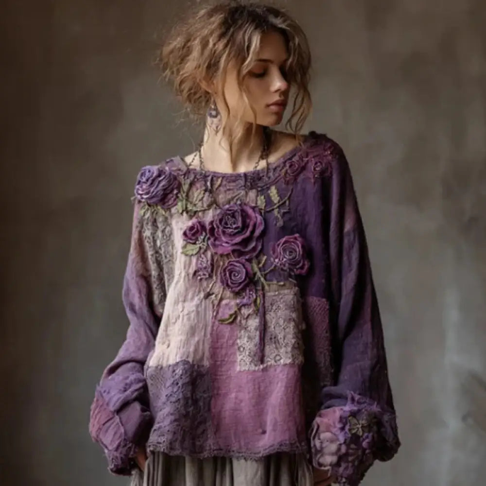 Woman wearing a purple embroidered blouse against a neutral background