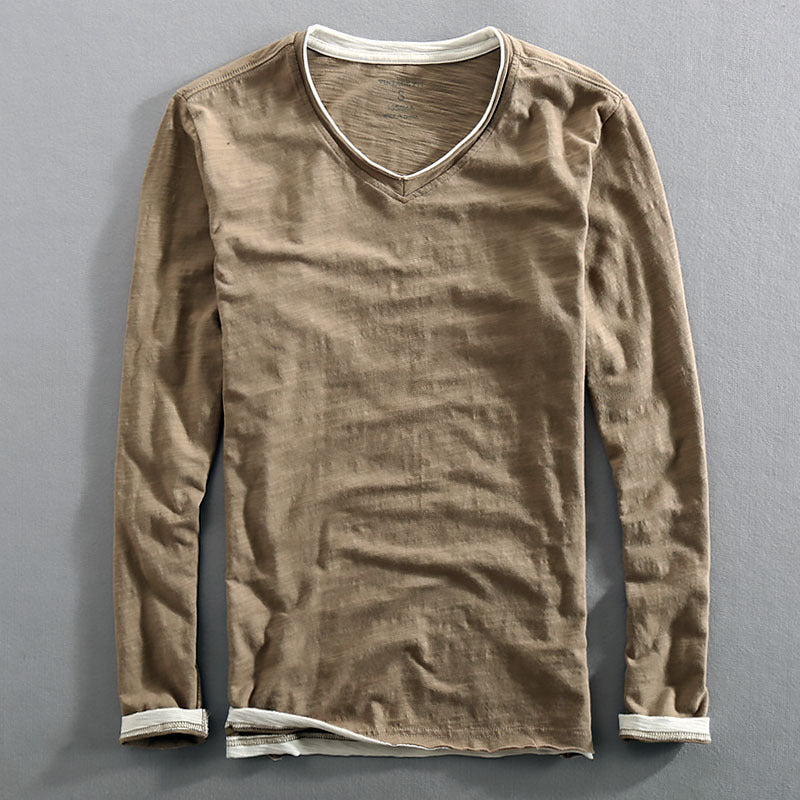 A long-sleeved men's undershirt in a solid color with a V-neck collar, sleeveless design, and a visible raw edge distressed detail at the neckline.