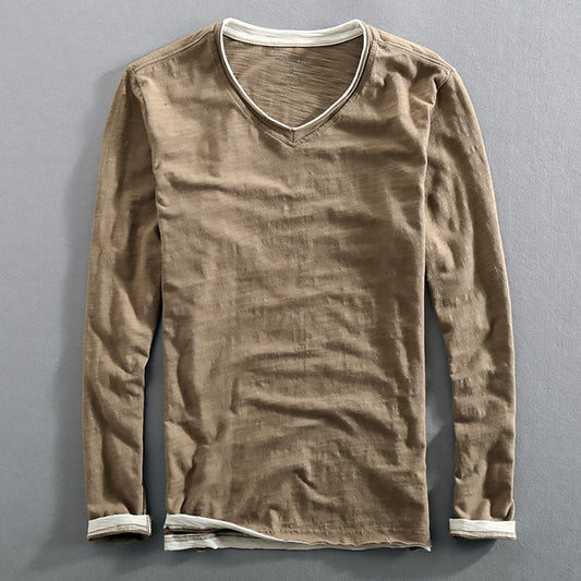 A long-sleeved men's undershirt in a solid color with a V-neck collar, sleeveless design, and a visible raw edge distressed detail at the neckline.