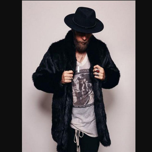 Person wearing a black fur coat and hat with a graphic t-shirt underneath on a plain background