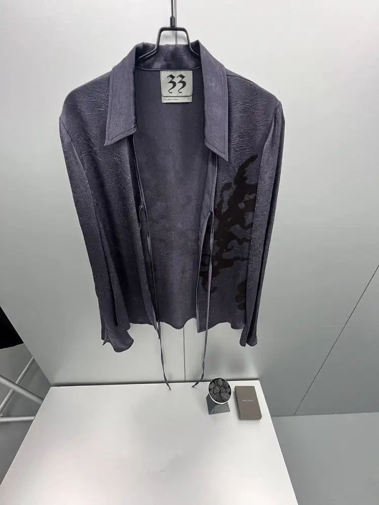 Dark gray jacket on a hanger with a visible brand label against a white background