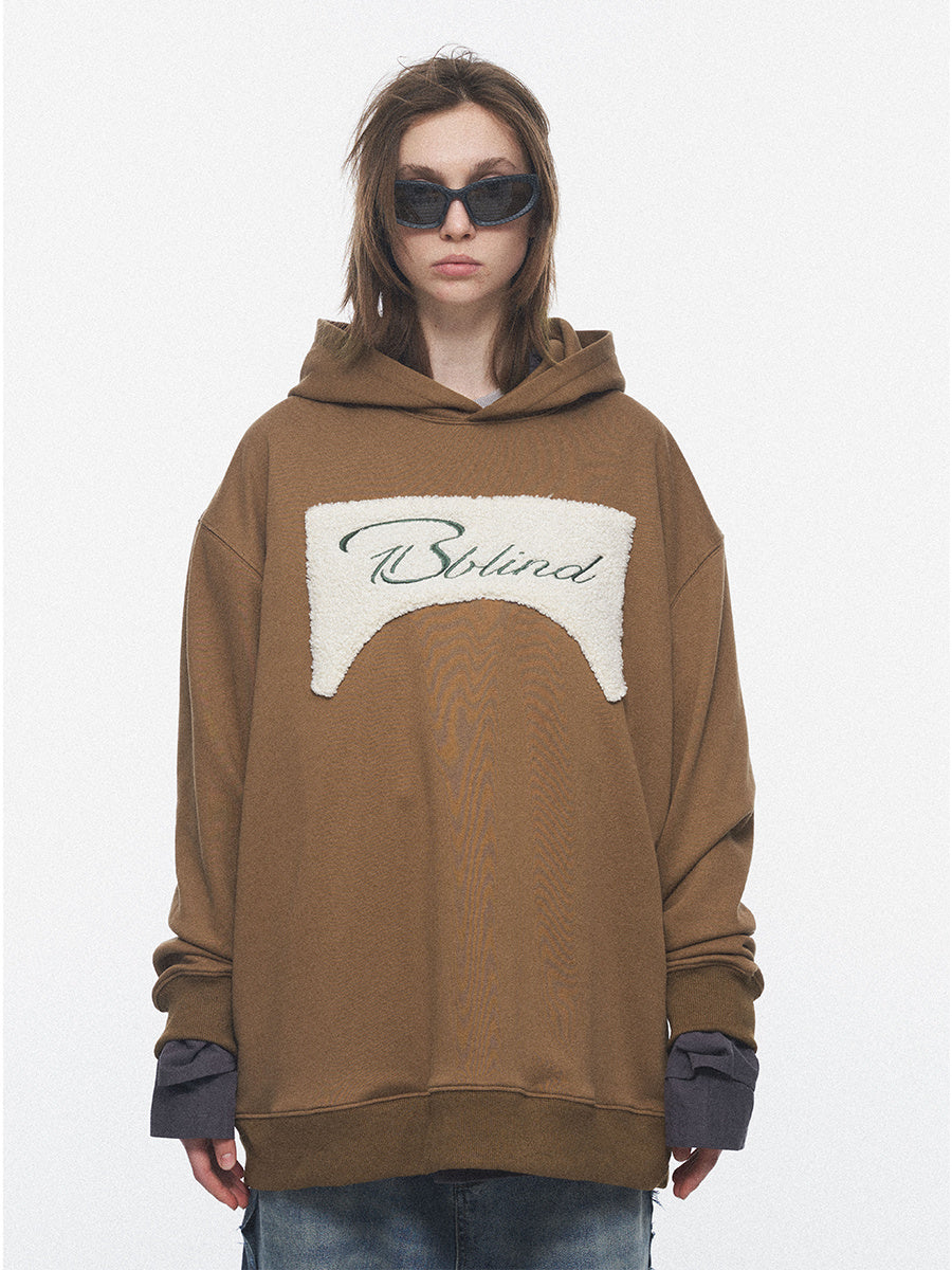 Person wearing a brown hoodie with a logo on a white background