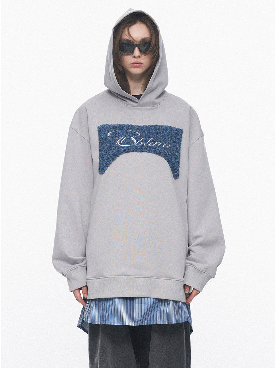 Person wearing a gray hoodie with a blue logo on a white background