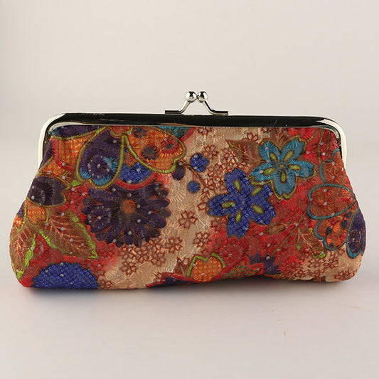 Colorful floral patterned clutch bag on a light gray background
