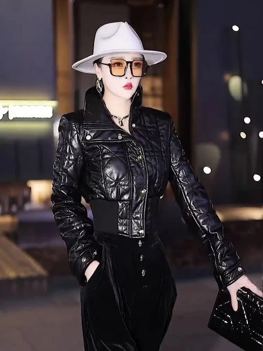Person wearing a black quilted jacket and white hat in an urban setting