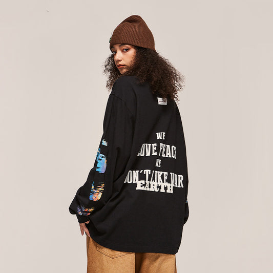Person wearing a black oversized sweatshirt with text on the back, standing against a plain background