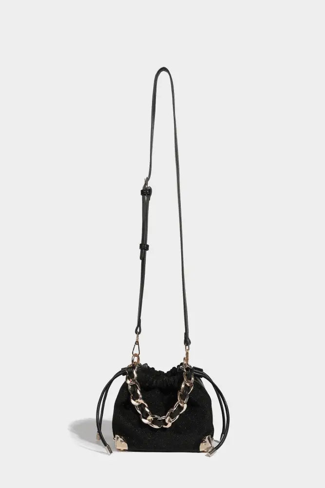 Black drawstring bag with gold chain detail on a white background