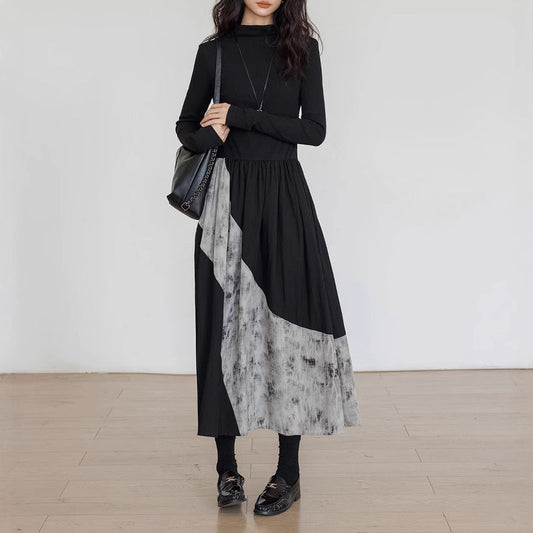 Woman wearing a black and gray dress with a white background