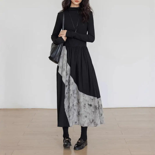 Woman wearing a black and gray dress with a white background
