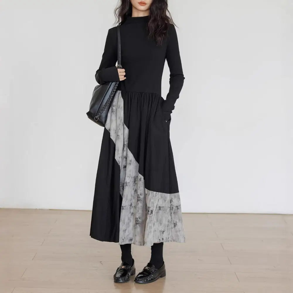 Person wearing a black and gray dress with a white background