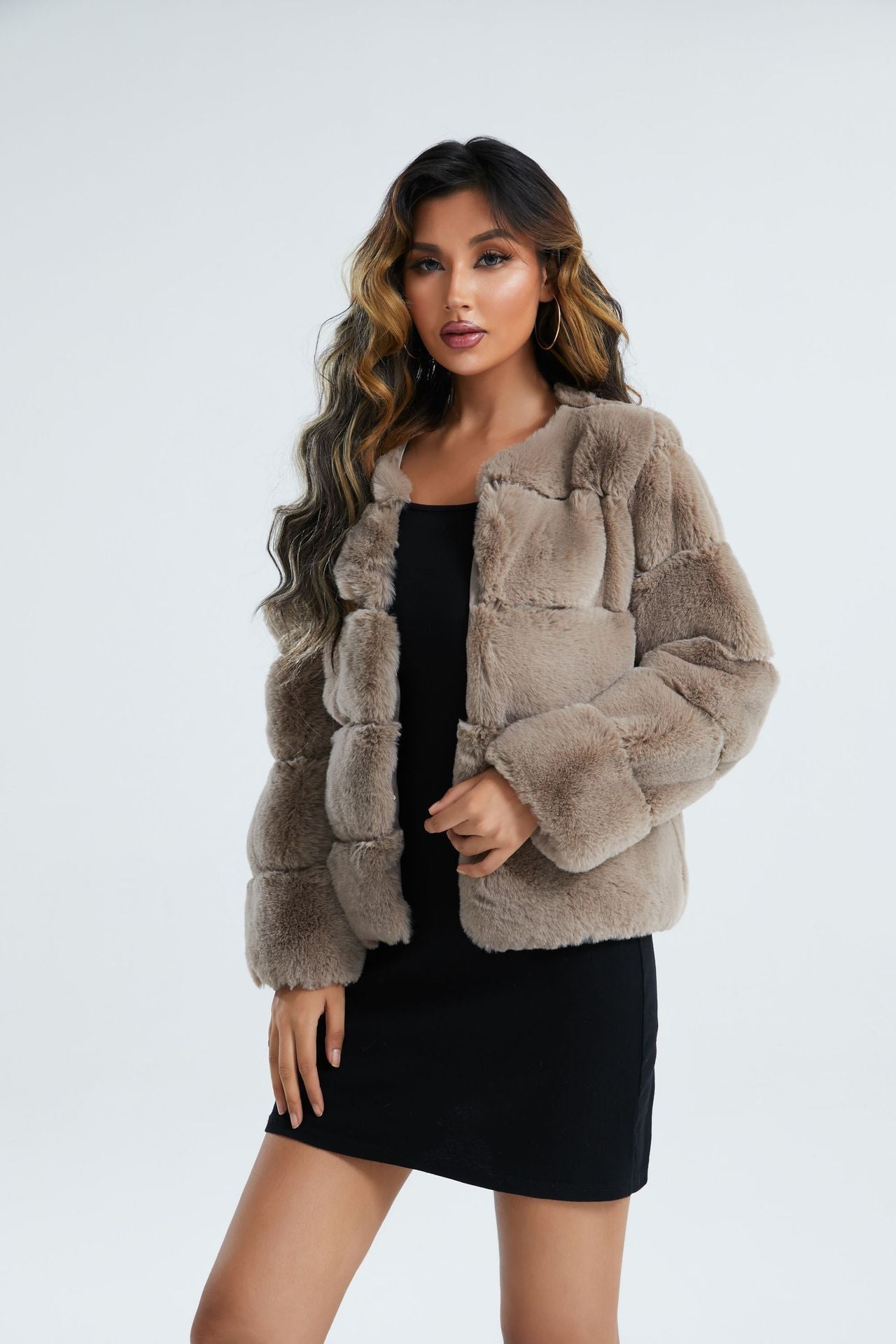 Woman wearing a beige faux fur jacket on a white background