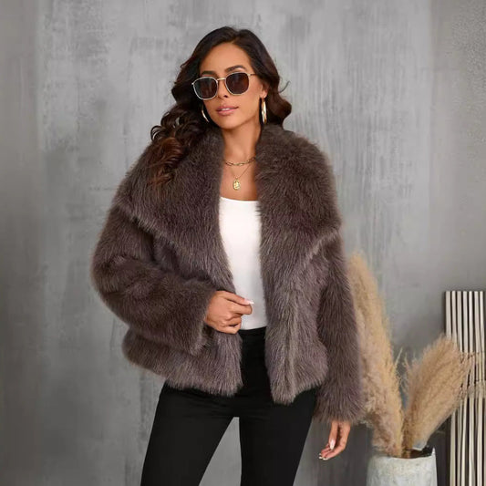 A female model wearing a large lapel fluffy plush artificial fur coat in brown color with long sleeves.