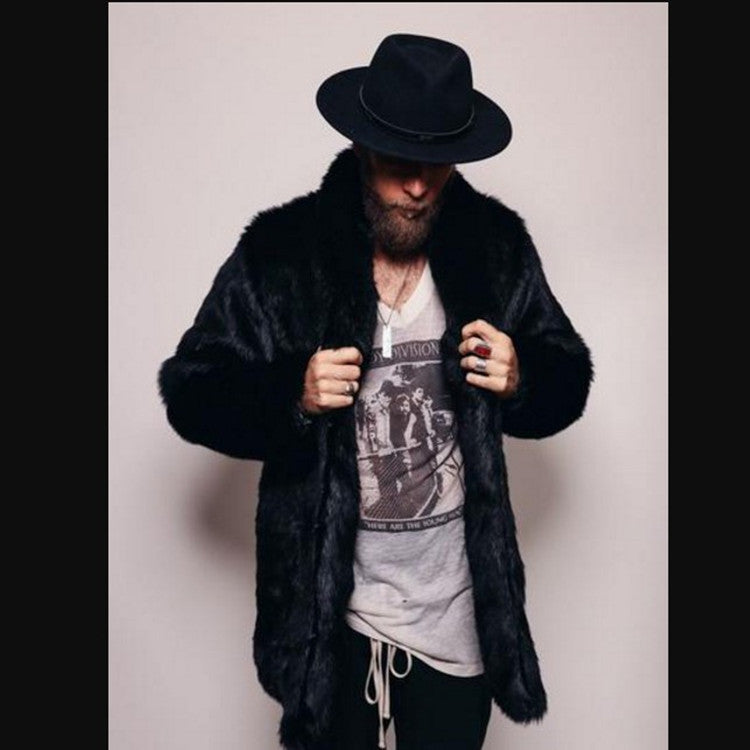 Person wearing a black fur coat and hat with a graphic t-shirt underneath on a plain background