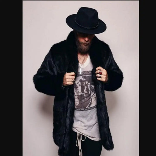 Person wearing a black fur coat and hat with a graphic t-shirt underneath on a plain background