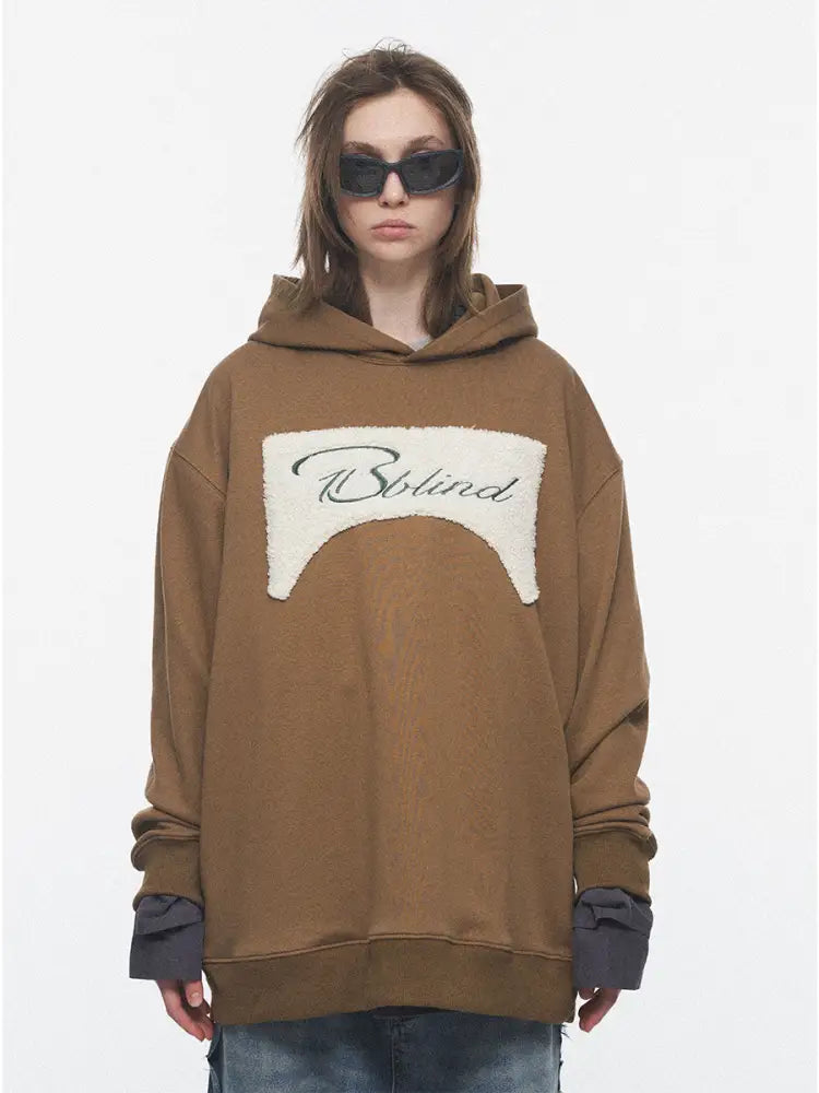 Person wearing a brown hoodie with a logo on a white background