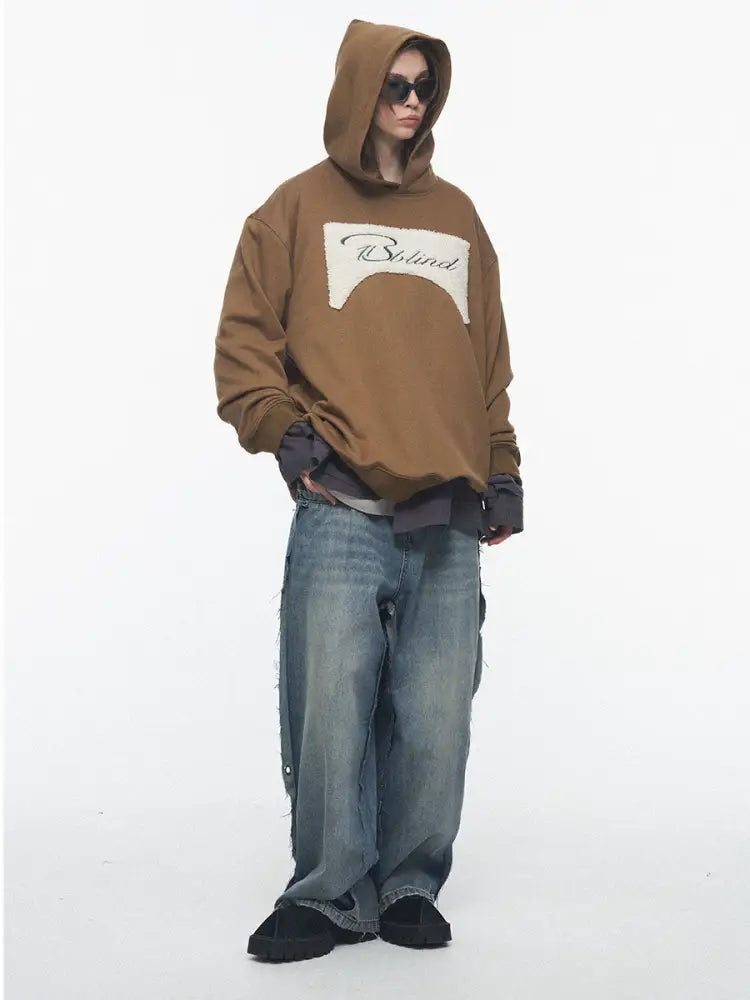 Person wearing a brown hoodie with a logo on a white background