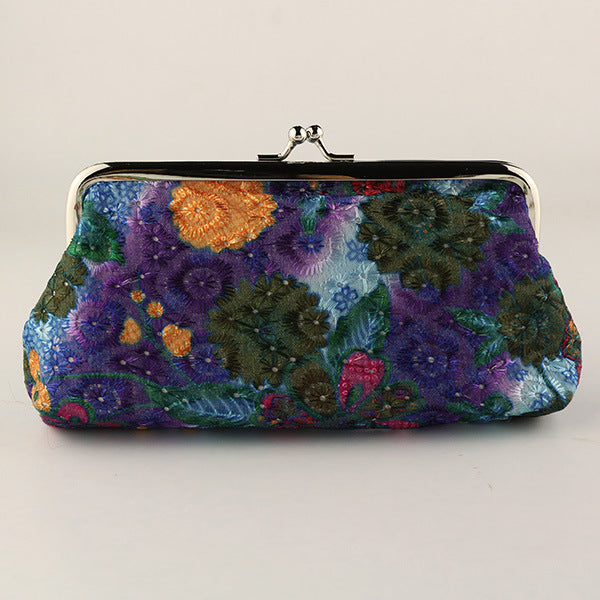 Colorful embroidered clutch bag on a light gray background