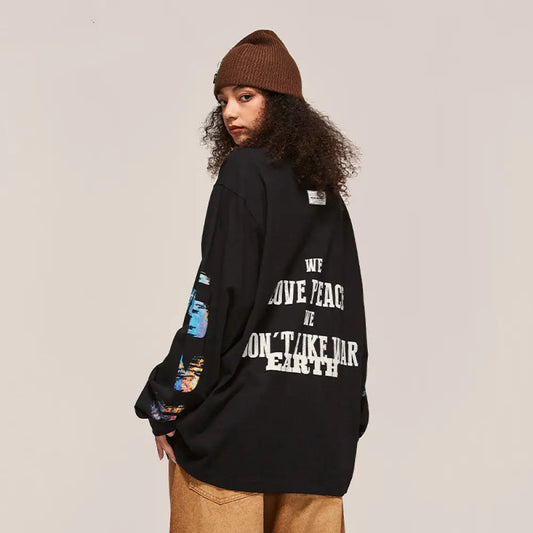 Person wearing a black oversized sweatshirt with text on the back, standing against a plain background
