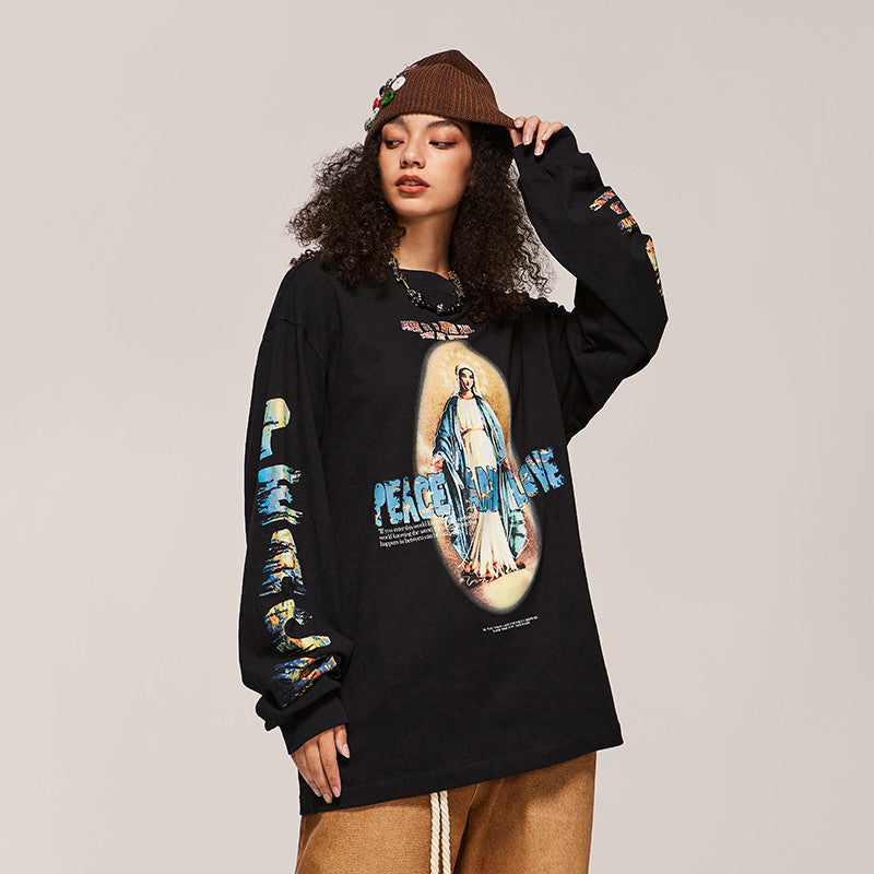 Person wearing a black long-sleeve shirt with a graphic design on a beige background