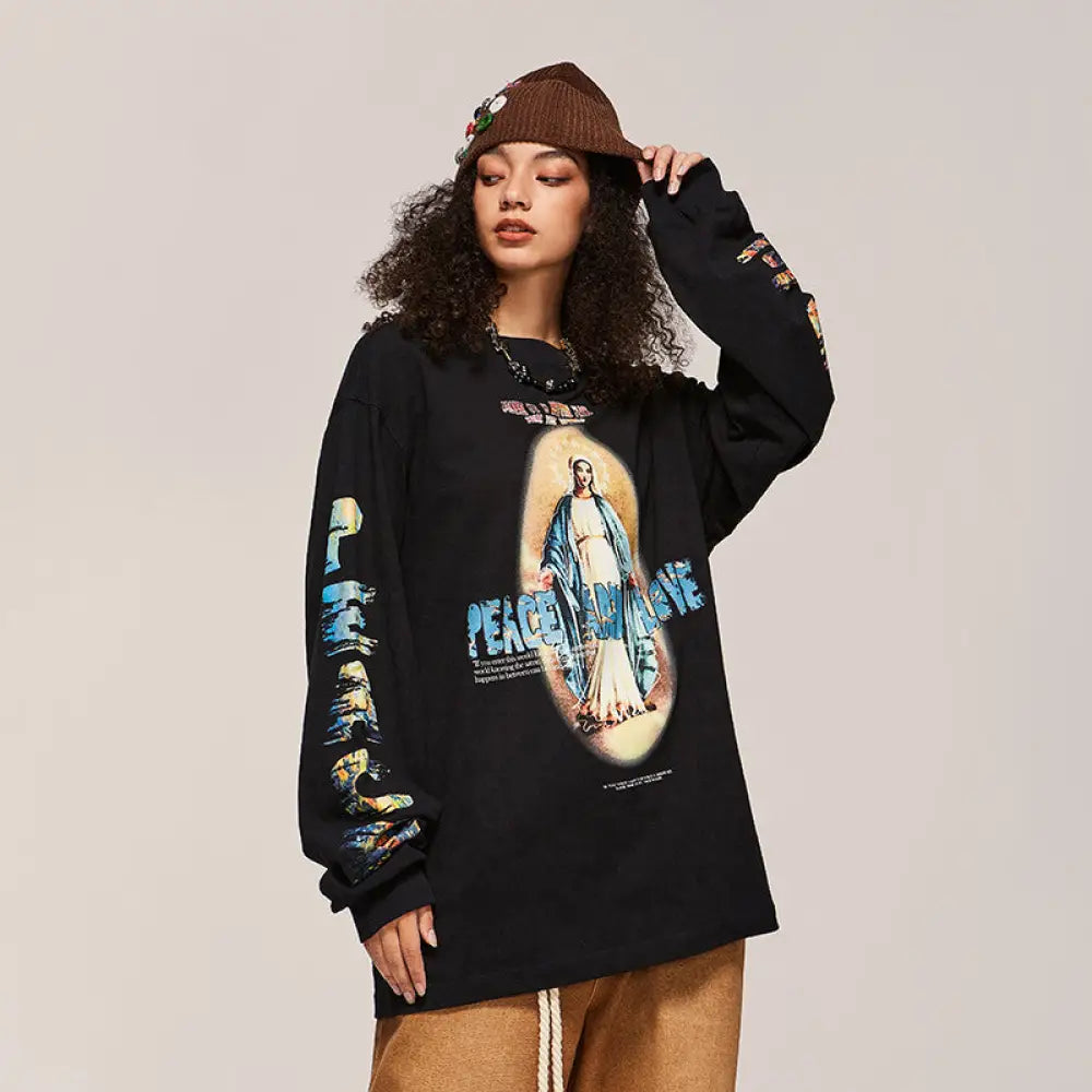 Person wearing a black long-sleeve shirt with a graphic design on a beige background