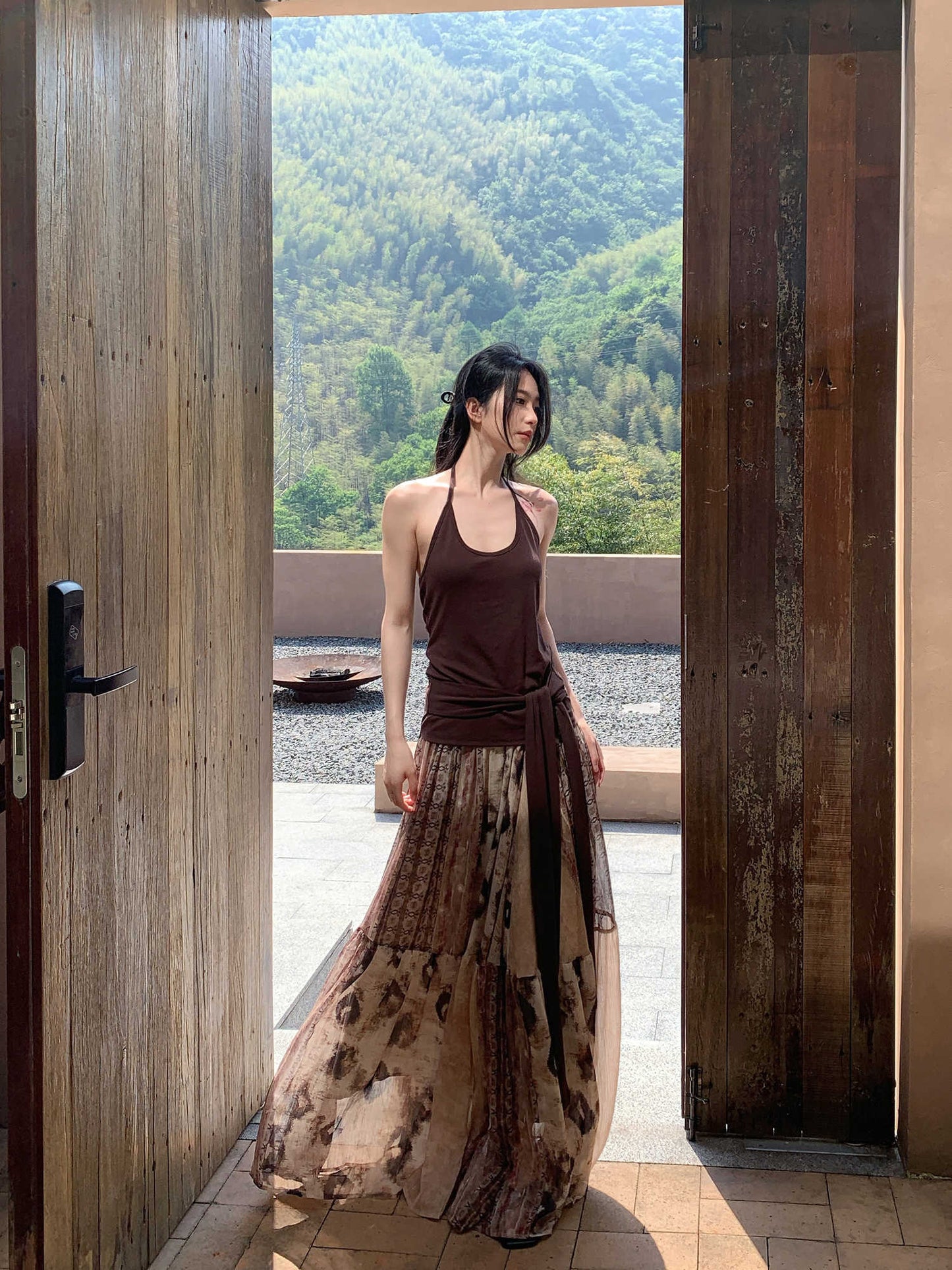 Woman standing in a doorway with a scenic mountain view outside