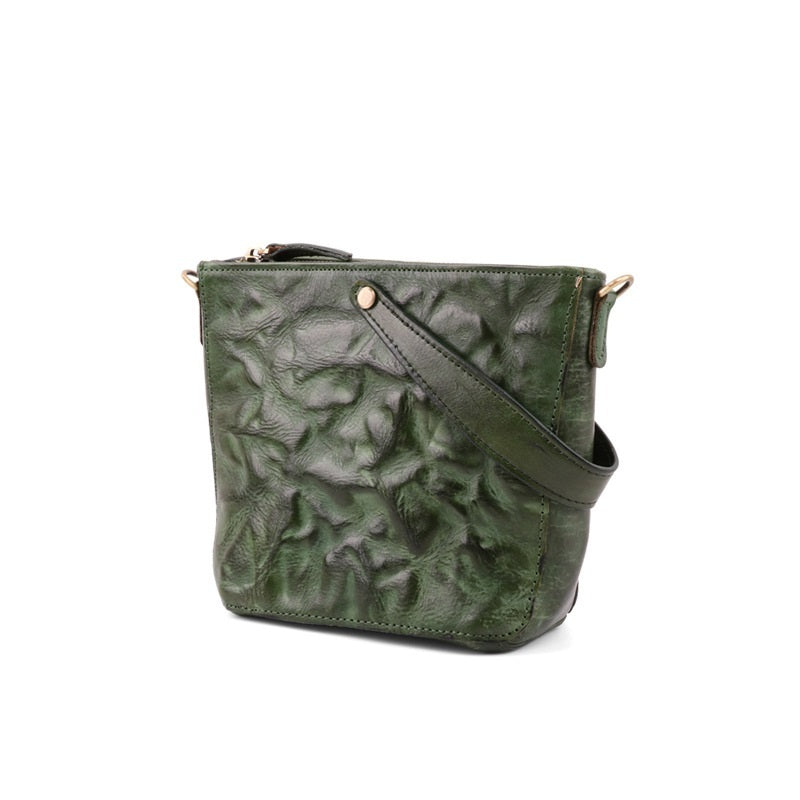 Green textured handbag with a strap on a white background